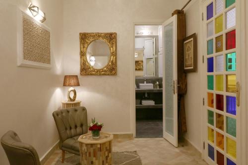 a hallway with a chair and a mirror at Riad Andallaspa in Marrakesh