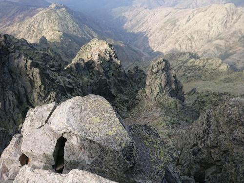 a view of a mountain range with a large rock at Artesano II in Navarredonda de Gredos