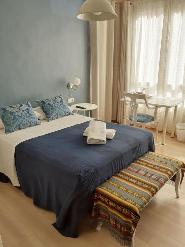 a bedroom with a large bed with a blue blanket at Pension Arena Alicante in Alicante