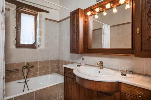 La salle de bains est pourvue d'un lavabo, d'une baignoire et d'un miroir. dans l'établissement Xatheri Villas, à Vámos