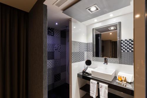 een badkamer met een wastafel en een spiegel bij Sant Jordi Boutique Hotel in Calella