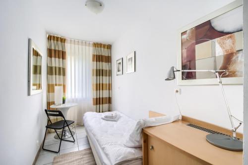 Schlafzimmer mit einem Schreibtisch und einem Bett in einem Zimmer in der Unterkunft 404 Rooms Zamiany Ursynow in Warschau