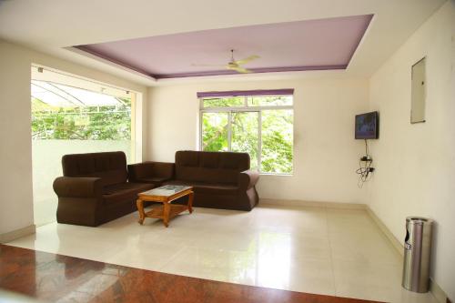 a living room with a couch and a table at V bee Plaza in Trivandrum