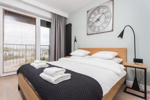 sypialnia z dwoma łóżkami i zegarem na ścianie w obiekcie City of the Kings-Bijou Apartment w Krakowie