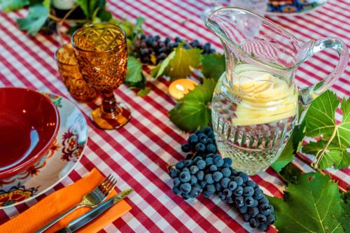 a table with a bunch of grapes and a pitcher of juice at Villa Pongina with private pool in Montevarchi