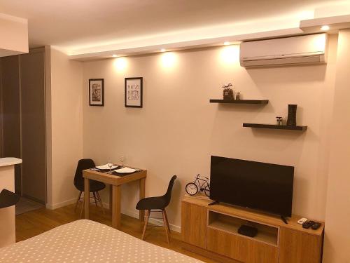 a room with a television and a table with chairs at Apartment Maximus lux in Belgrade