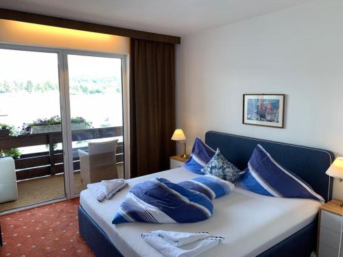 a bedroom with a large bed with blue pillows at Clubdorf Galtür GmbH Veldener Traumschiff in Velden am Wörthersee