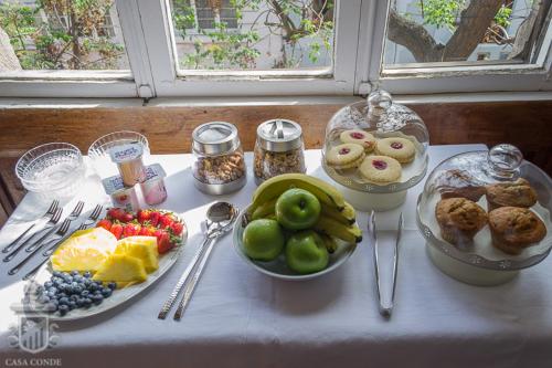a table topped with plates of food and fruit at Hotel Boutique Casa Conde in Santiago