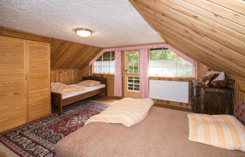 a bedroom with two beds and two windows at Vacation house KURTOVEC in Benešov nad Černou