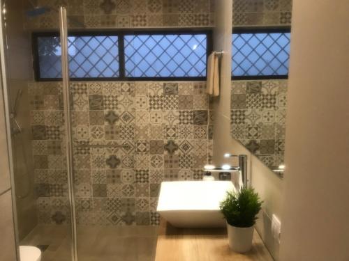 ein Badezimmer mit Waschbecken und Glasdusche in der Unterkunft San Agustín Seaviews and flowers in San Agustín