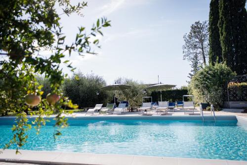 uma piscina com cadeiras e guarda-sóis em Agriturismo La Meridiana em Guidonia