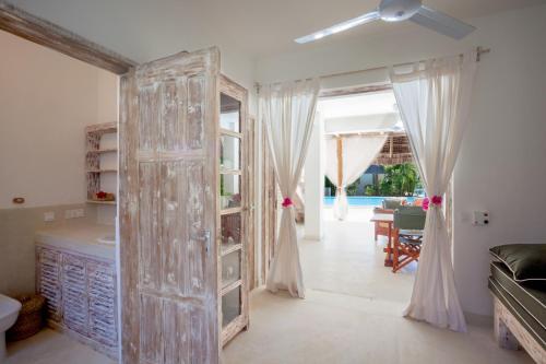 une porte ouverte dans une pièce avec un salon dans l'établissement Swordfish Villas, à Malindi