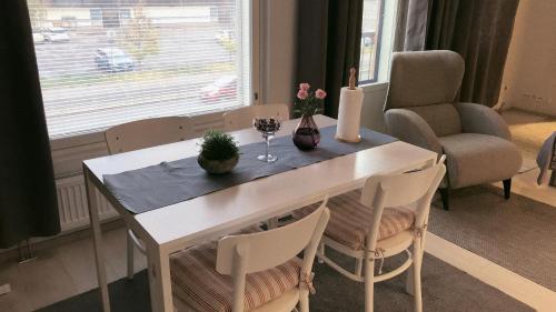 a dining room table with two chairs and flowers on it at Sunshine Apartment in Turku