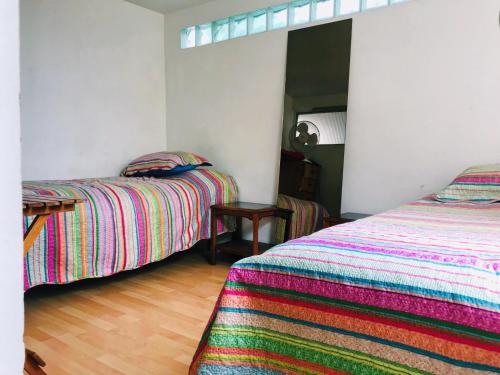 a bedroom with two beds and a wooden floor at Hostal Pampaloja Antof in Antofagasta