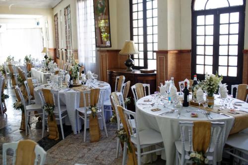 a room with tables and chairs with white tablecloths at Relais De La Haute Ville Tana in Antananarivo
