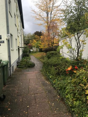 Cozy Room in Ludwigsburg في لودفيغسبورغ: مسار حجري بجانب مبنى ابيض