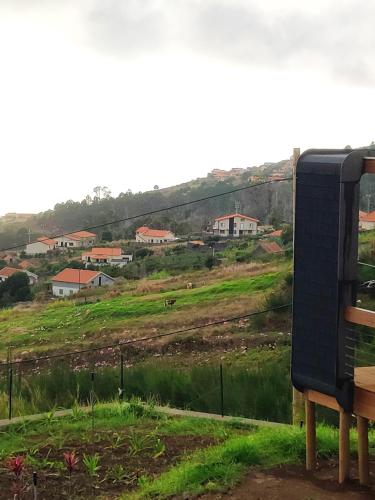 a view of a field with houses on a hill at Calheta Glamping Pods - Nature Retreat in Calheta