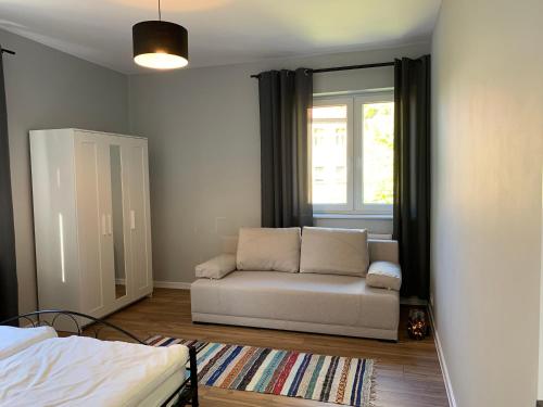 een woonkamer met een bank en een raam bij Grey apartment 50 m2 in Tarnowskie Góry