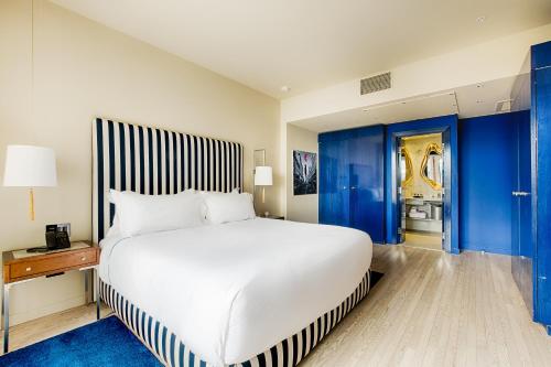 a bedroom with a large white bed and blue walls at Monsieur Jean - Hôtel Particulier in Quebec City