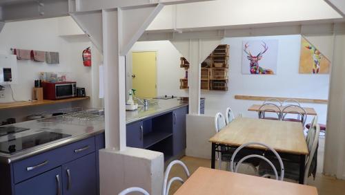a kitchen with blue cabinets and a wooden table at Centabay Lodge and Backpackers in Paihia