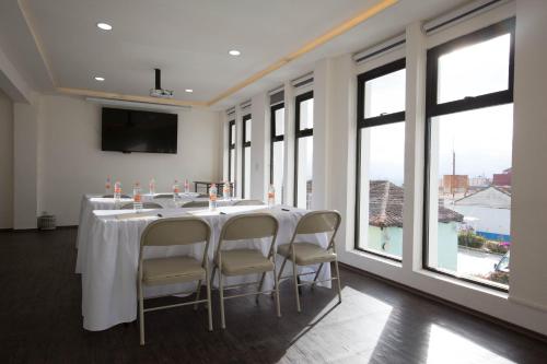 a conference room with a long table with chairs and windows at Hotel Lunada in Comitán de Domínguez