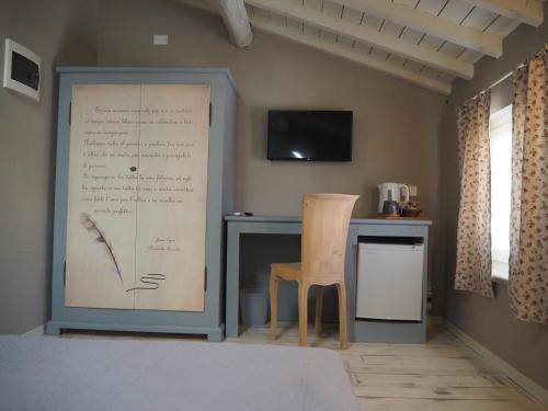 a room with a desk and a chair and a television at B&B Antique Maison in Soave