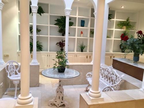 Casa Modernista "La Trinidad" في ساغونتو: غرفة بها كراسي بيضاء وطاولة مع نباتات الفخار