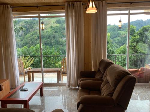 a living room with a couch and a large window at Country Homes in Ella