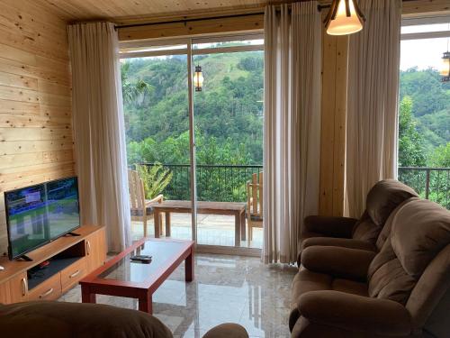 a living room with a couch and a large window at Country Homes in Ella