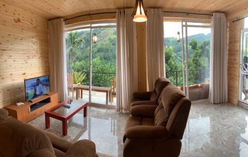 a living room with couches and a large window at Country Homes in Ella