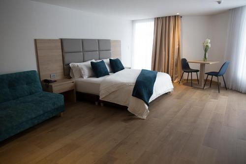 a bedroom with a bed and a couch and a table at Turrim Dei Hotel Boutique in Barbosa