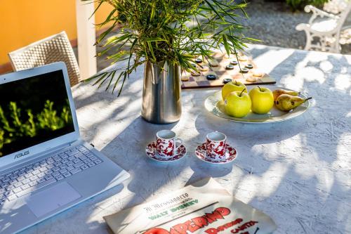 a laptop computer sitting on a table with a vase at Villa Pongina with private pool in Montevarchi