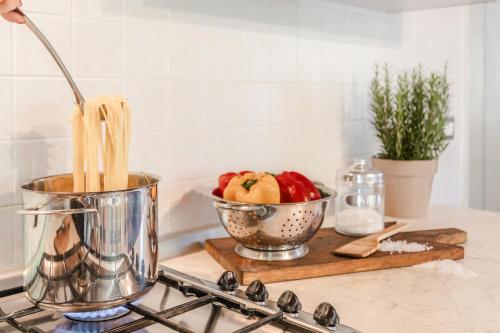 a kitchen counter with a bowl of apples and a pot of spaghetti at Villa Pongina with private pool in Montevarchi