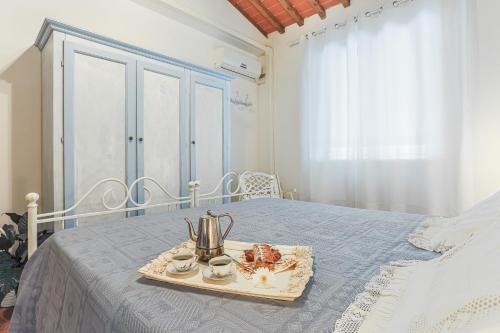 a tray with a tea kettle and cups on a bed at Villa Pongina with private pool in Montevarchi