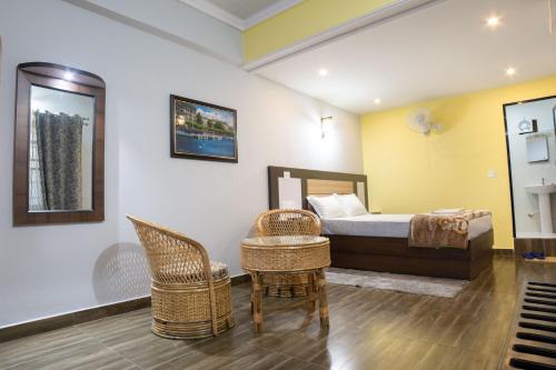 sypialnia z łóżkiem i wiklinowymi krzesłami w obiekcie Galaxy Guest House w Bhairāhawie