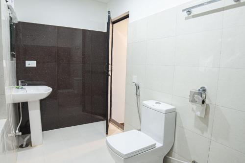 a bathroom with a toilet and a sink and a shower at Galaxy Guest House in Bhairāhawā