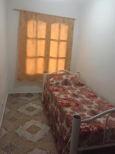1 dormitorio con cama y ventana con cortina en Departamento Libertad en San Salvador de Jujuy