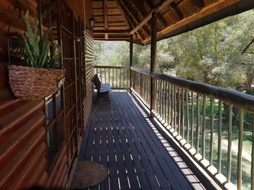 a porch of a cabin with a bench on it at Cozy Wood Cabin in Pretoria