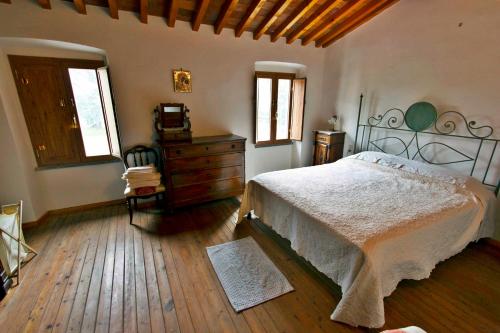 a bedroom with a bed and a dresser and windows at Villa Magni in Pistoia