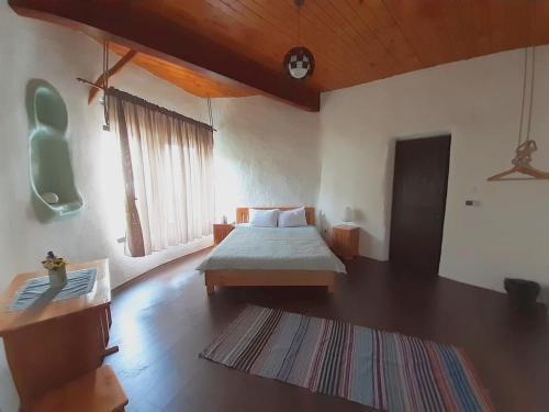 a bedroom with a bed and a rug at Cob Village in Berca