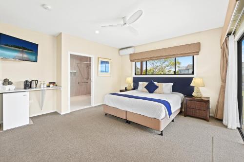 a bedroom with a large bed and a bathroom at Ana Mandara Luxury Retreat in Port Macquarie