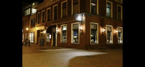 an empty street in front of a building at night at b&b het Herenhuys aan de historische gracht van Kollum in Kollum