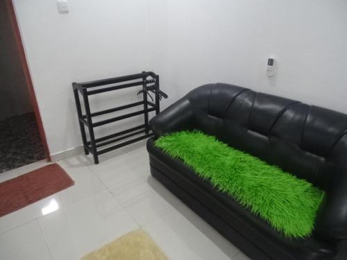 a black leather couch with green grass on it at Lovely lodge & Hostel in Sigiriya