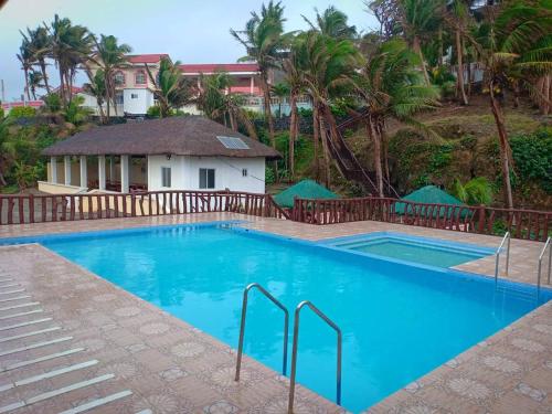 una gran piscina azul con una casa en el fondo en Amerie Rae Resorts, en Bangui