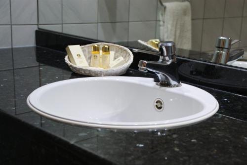 a sink in a bathroom with a soap dispenser at Best Western Plus Park Hotel Brussels in Brussels