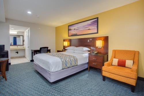 a hotel room with a bed and a chair at Quality Inn San Diego South - Chula Vista in Chula Vista