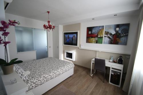 1 dormitorio con 1 cama y escritorio con ordenador en H5-5H Luxury Room, en Maranello