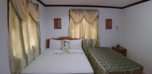 um pequeno quarto com uma cama e uma janela em Isla de Paz Beach Resort em Siquijor