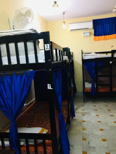 a room with four bunk beds with blue curtains at Hotel Tokyo Palace in Jaisalmer