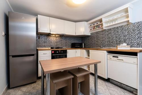 a kitchen with a stainless steel refrigerator and a wooden table at Cozy, quiet & family friendly in Arad in Arad